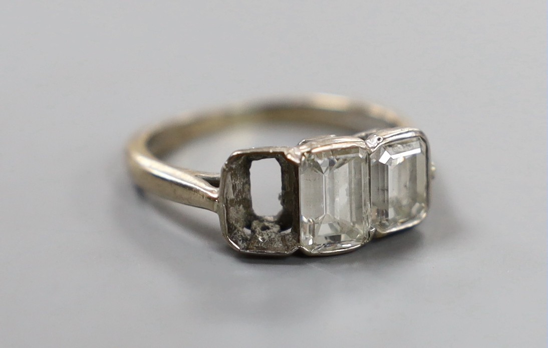 A modern 18ct white gold and two (ex three) stone graduated emerald cut diamond set ring, size G, gross weight 3.3 grams